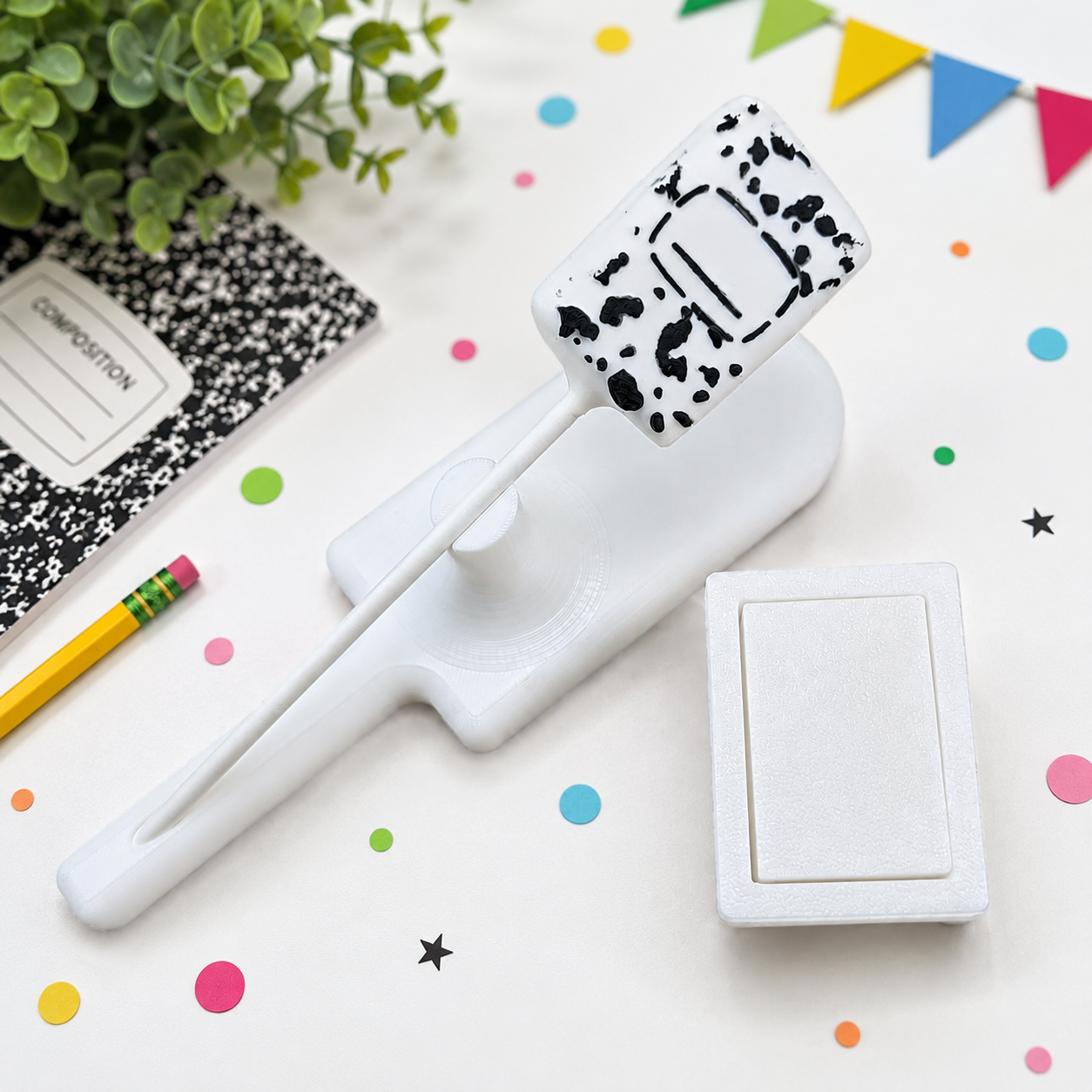 HGB3D rectangle composition book cake pop cutter and pusher with finished cake pop, shown on white surface 